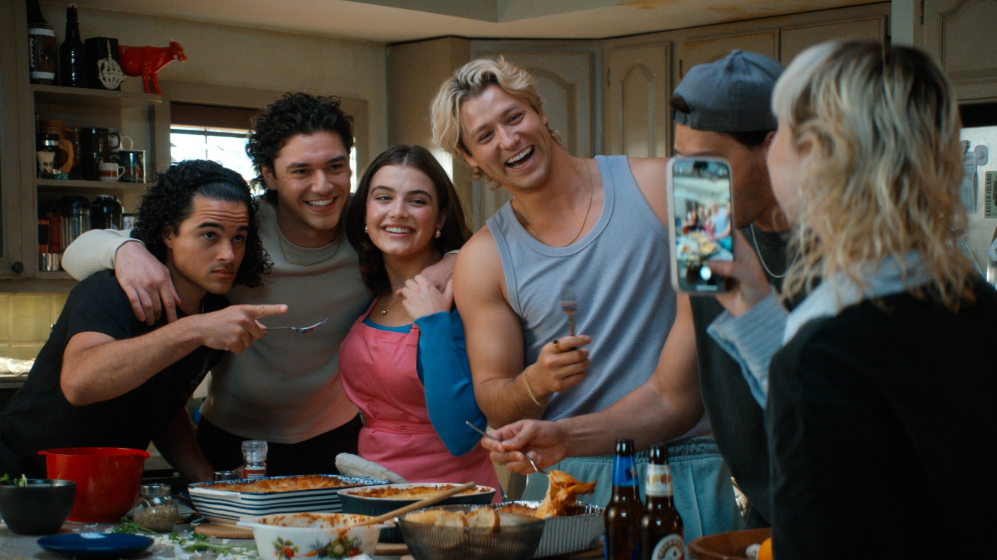 Off Campus — friends posing for a photo around a kitchen table